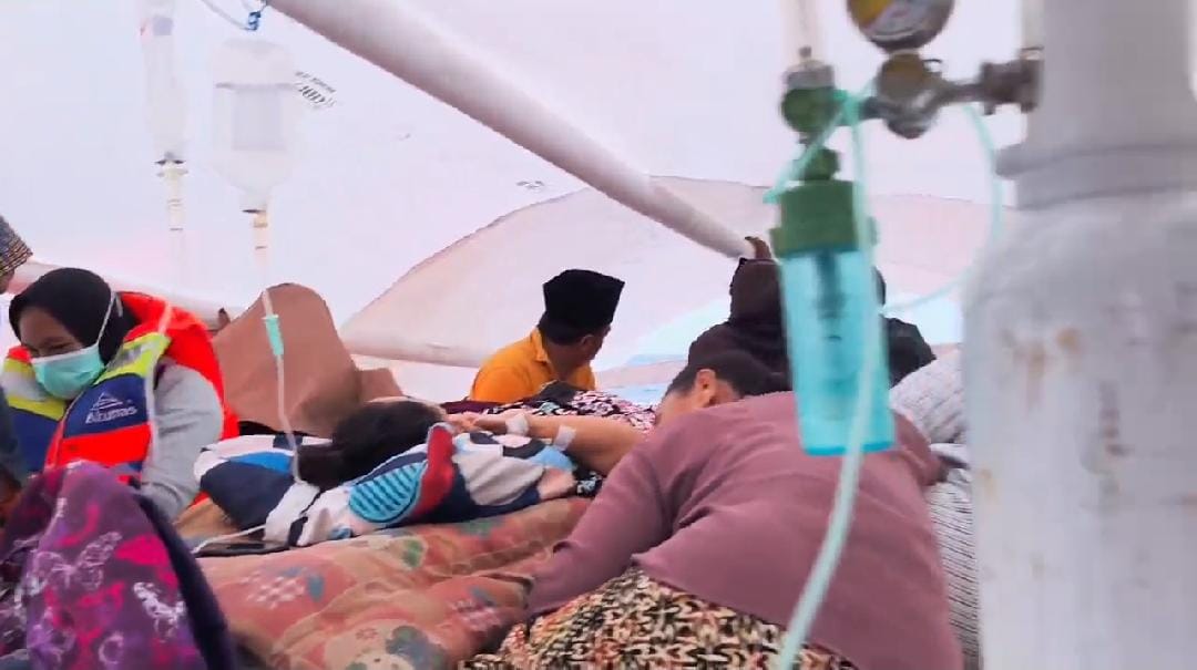 Tampak pasien asal PKM Gayam diatas perahu dengan peralatan medis (oksigen dan infus)
